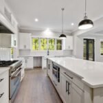 Modern, spacious white kitchen with an island, showing the immaculate results of a premier house cleaning service in Round Rock.