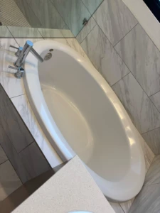 Sparkling clean white oval bathtub with polished chrome faucets, showcasing a detailed move out clean Austin result.